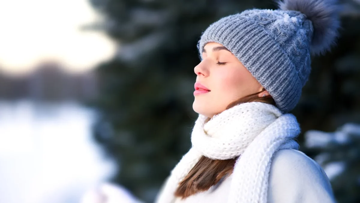 Woman is breathing deep fresh air in winter