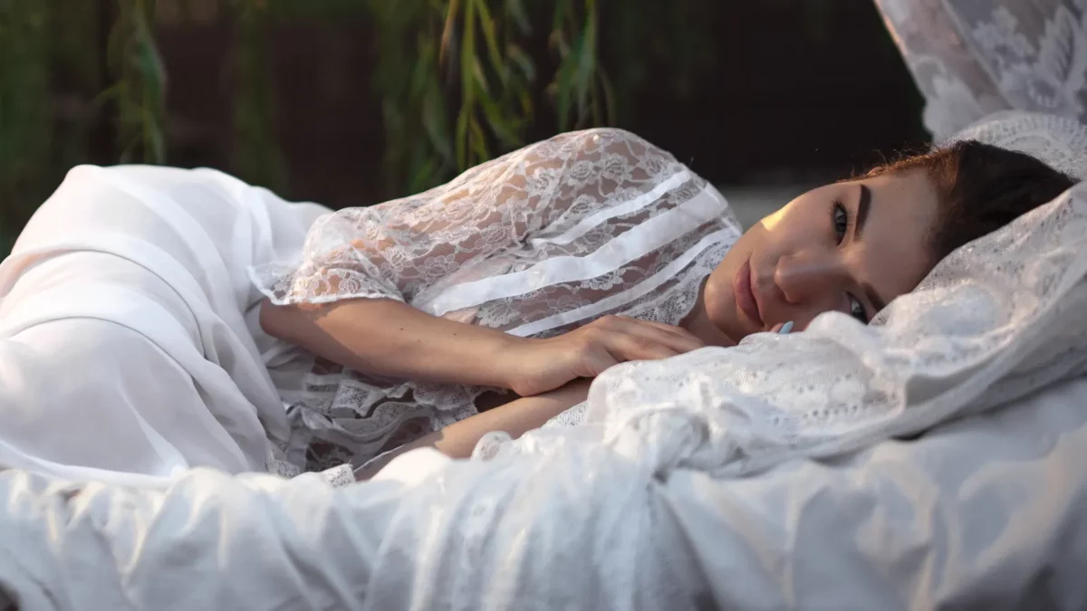 Woman lies on white bed silk pillowcase