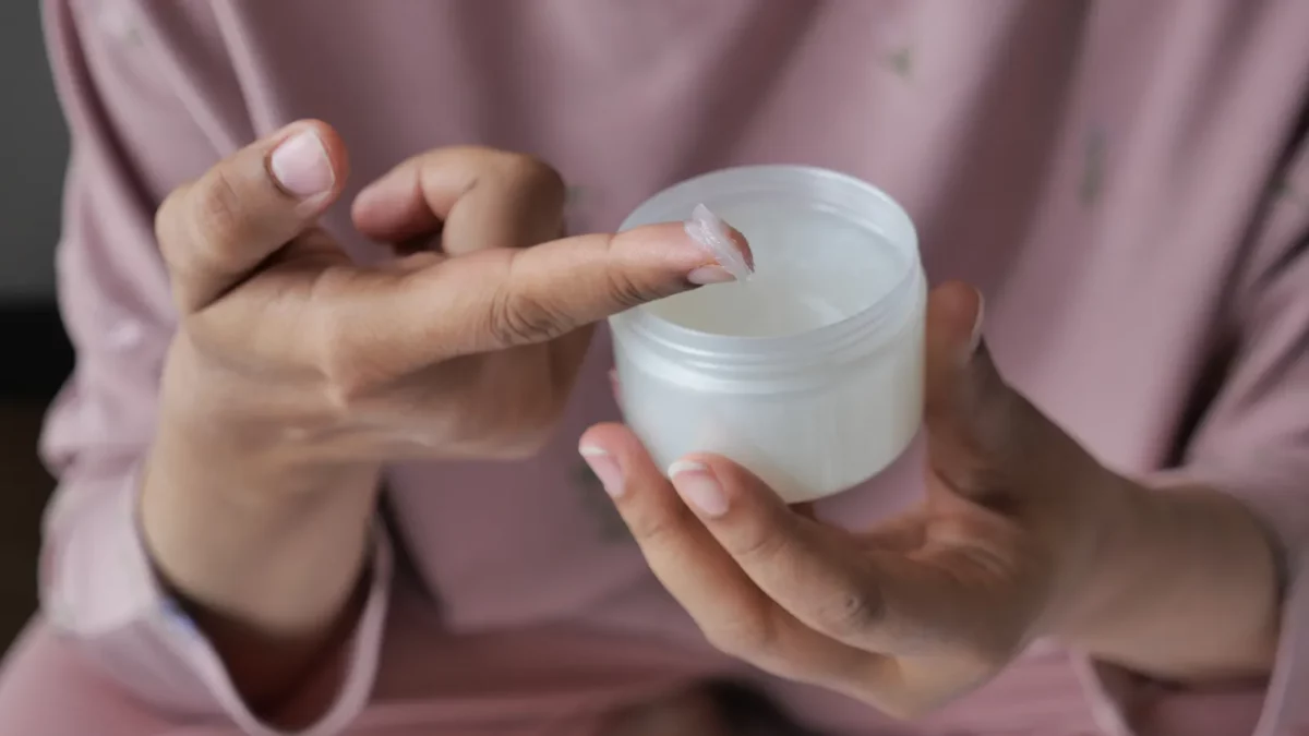 Woman using petroleum jelly onto skin at home