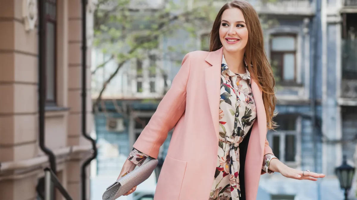 Woman walking in pink coat and floral printed dress