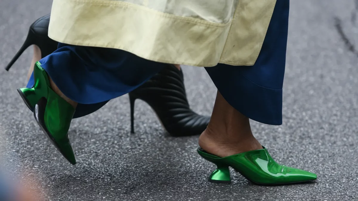 Woman wearing blue pants and pointy forest green shoes