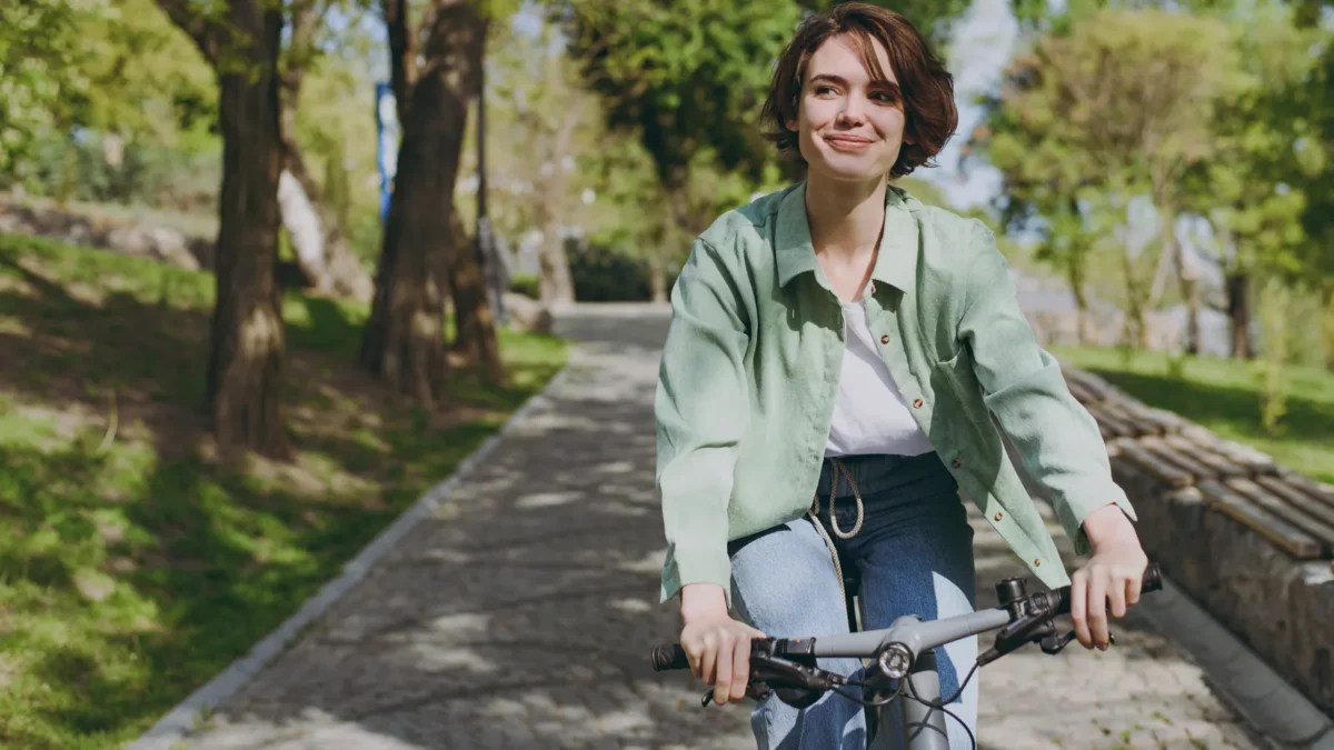 Woman wearing casual green jacket riding bicycle