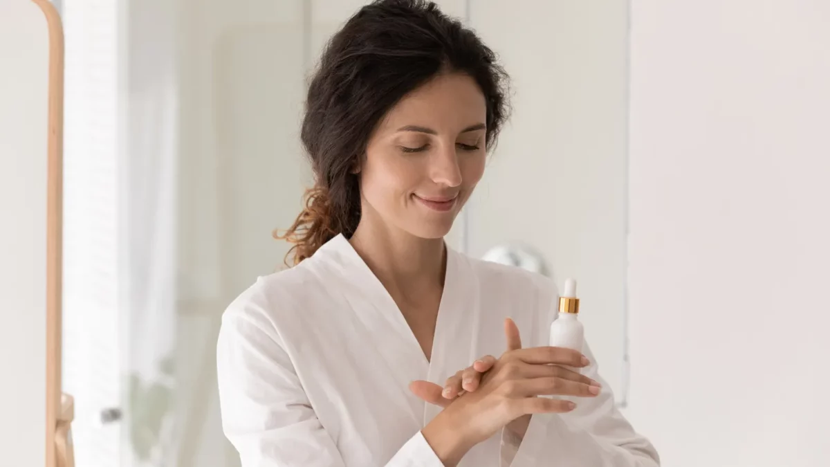 Young female using anti ageing serum