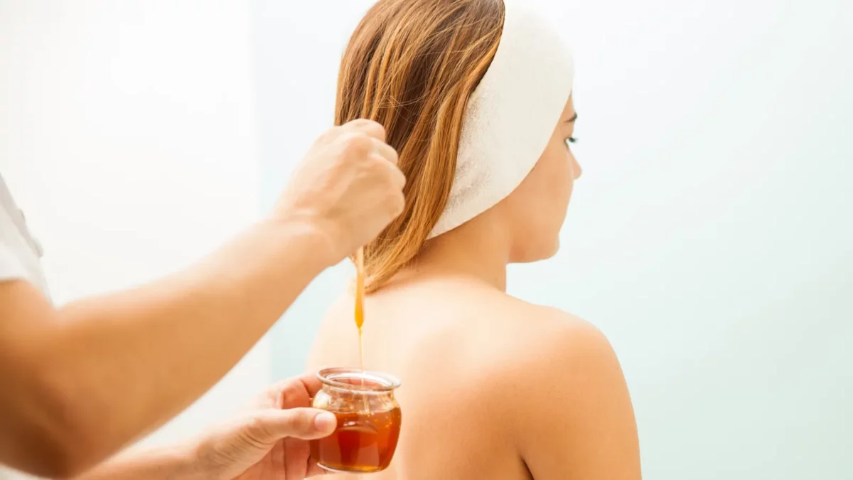 Young woman during a hair session with honey