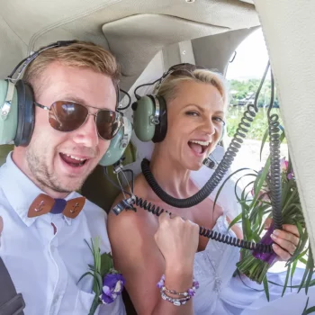 Happy wedding couple riding helicopter