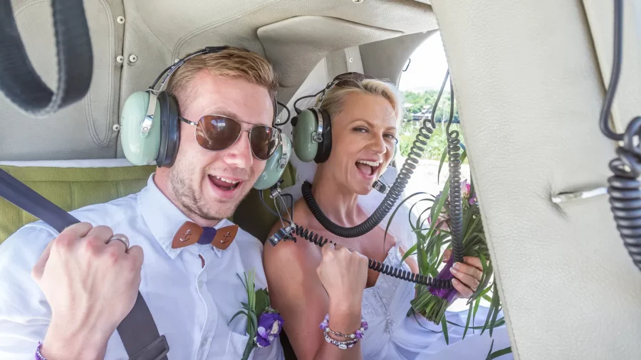 Happy wedding couple riding helicopter