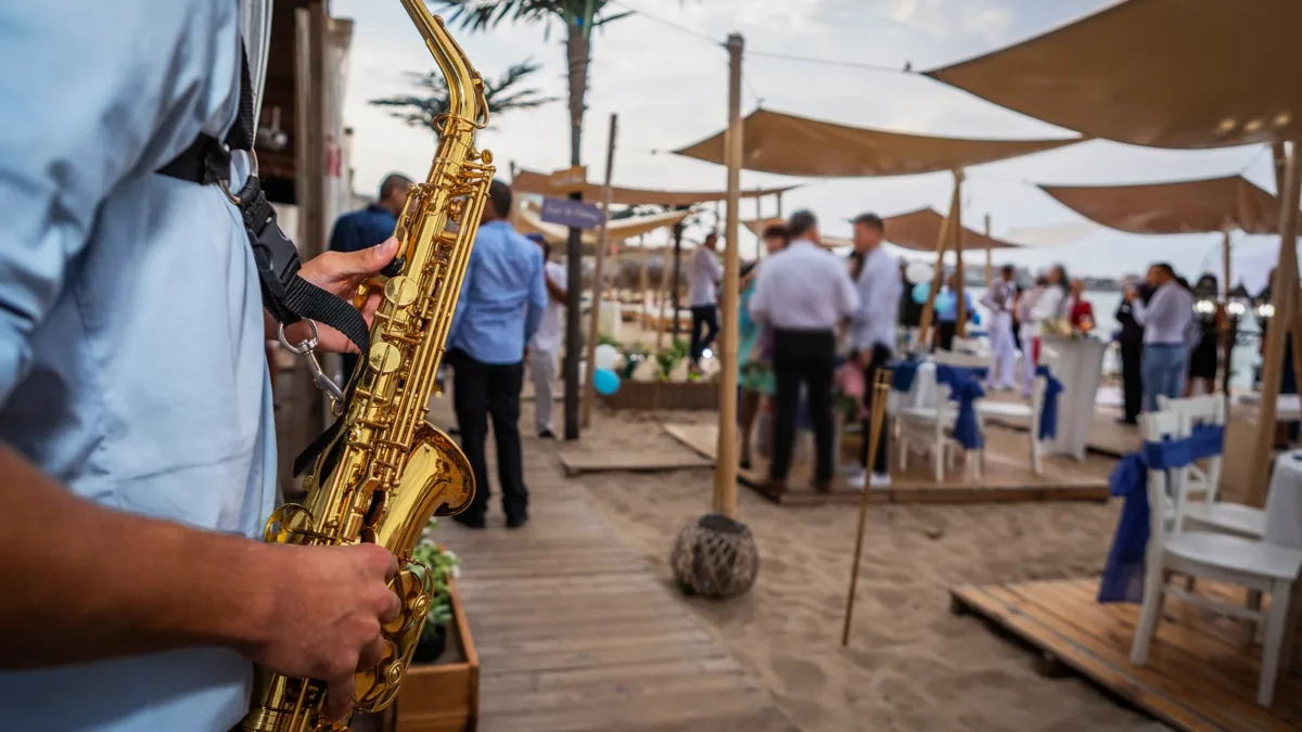 Saxophonist plays a wedding party on the beach