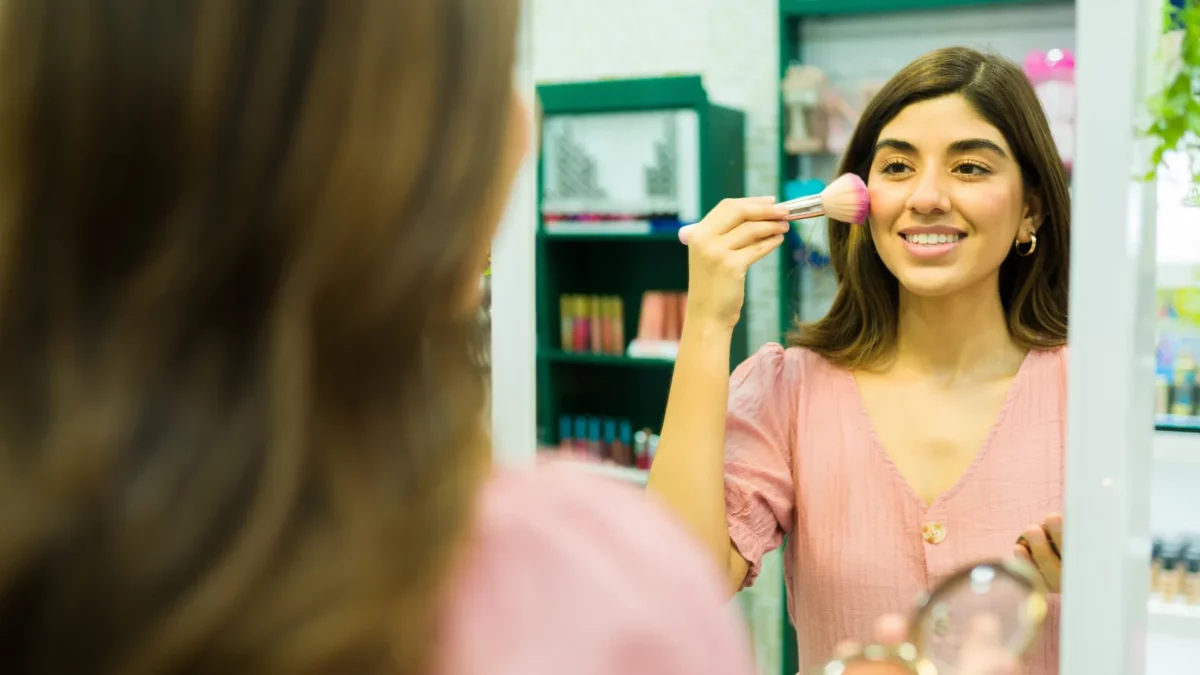 Woman smiling while doing makeup