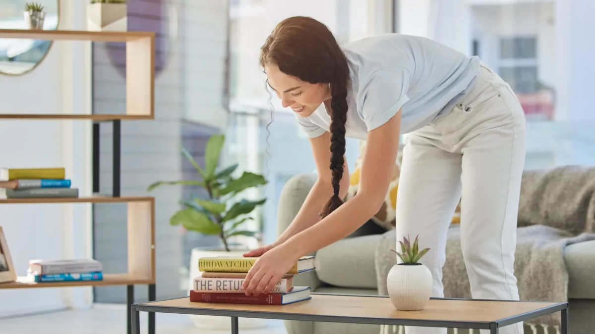 Woman tidy books in living room